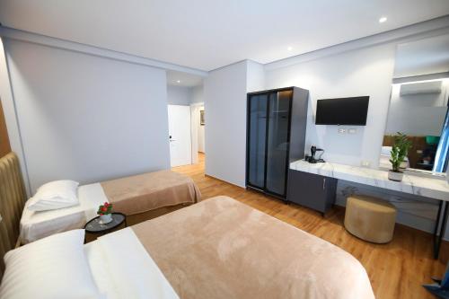a hotel room with two beds and a television at Ulcas guest huse in Vlorë