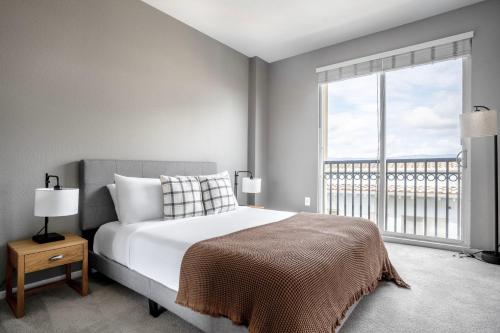 a bedroom with a bed and a large window at Santana Row 2br townhouse w pool nr highways SFO-1327 in San Jose