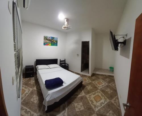 Schlafzimmer mit einem Bett und einem Flachbild-TV in der Unterkunft Hotel San Adolfo Carepa in Carepa