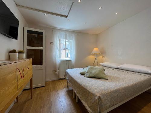 a bedroom with a bed and a dresser and a window at Casa Calle del Forno in Grado