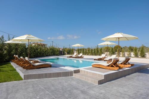 a swimming pool with lounge chairs and umbrellas at La Casa De Zante in Laganas
