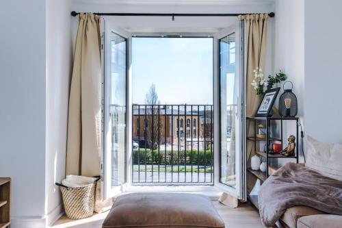 Schlafzimmer mit einer offenen Tür zu einem Balkon in der Unterkunft Full SKY TV Access 2BR Stylish Apartment in Hough Green