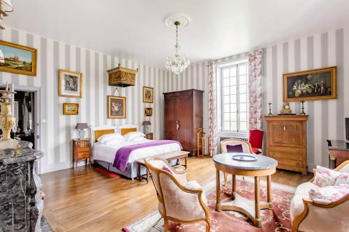 1 dormitorio con 1 cama, mesa y sillas en Château de Montbrault en Fleurigné