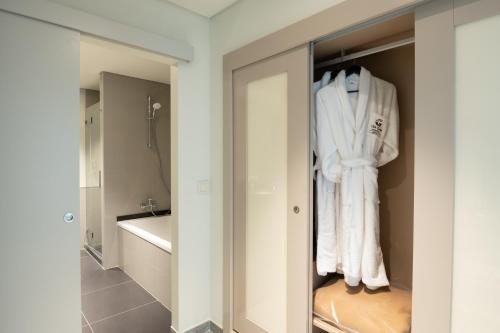 La salle de bains est pourvue d'un placard et de serviettes blanches. dans l'établissement Vila Gale Collection Monte do Vilar, à Albernoa