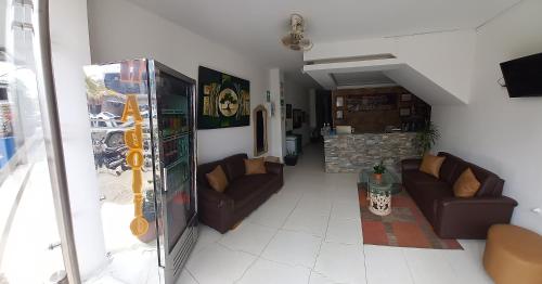 a living room with two brown couches at Hotel San Adolfo Carepa in Carepa