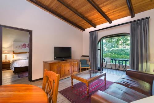 a living room with a couch and a tv at Malaga Hotel in Panorama