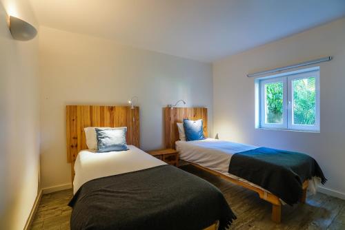 een slaapkamer met 2 bedden en een raam bij Quinta da Bicuda in Cascais