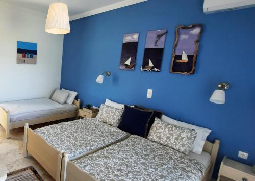 ein Schlafzimmer mit 2 Betten und einer blauen Wand in der Unterkunft ILEKTRA Apartments Blue & Red in Plataria