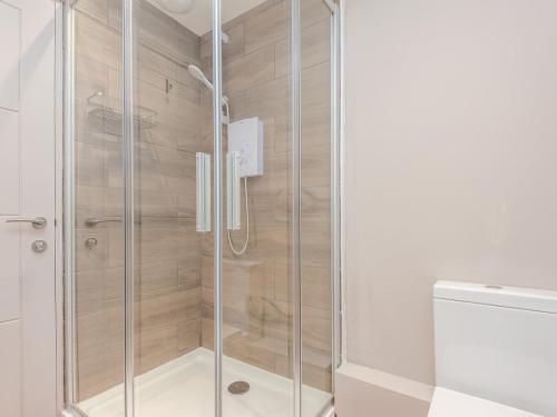 a shower with glass doors in a bathroom at Pass the Keys Luxurious Retreat with Workspace in Leeds