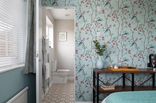 a bedroom with blue walls with a flowery wallpaper at Crookes House in Weston-super-Mare