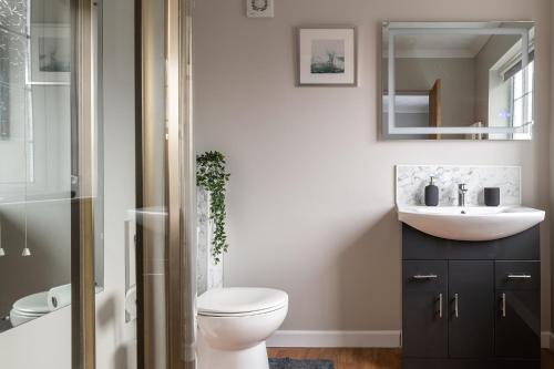 a bathroom with a white toilet and a sink at Crookes House in Weston-super-Mare