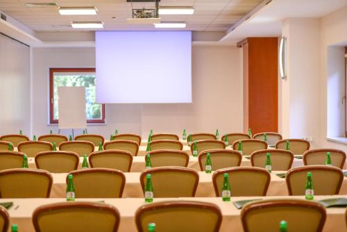 a conference room with tables and chairs and a screen at Hotel Belweder in Ustroń
