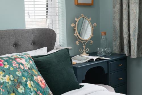 a bedroom with a table with a mirror and a bed at Crookes House in Weston-super-Mare