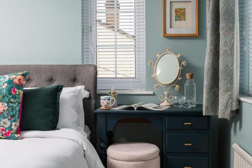 a bedroom with a bed and a desk with a mirror at Crookes House in Weston-super-Mare