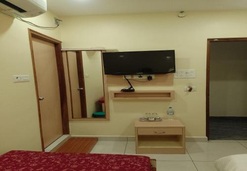 a room with a flat screen tv on the wall at Nadanam Inn in Puducherry