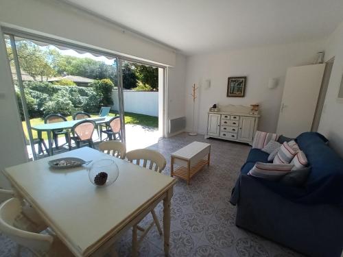 a living room with a blue couch and a table at Pyla-sur-mer maison 2 chambres et jardin - à 400m des plages in La Teste-de-Buch