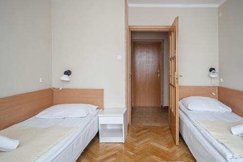 a bedroom with two beds and a table and a door at Wanta in Zakopane