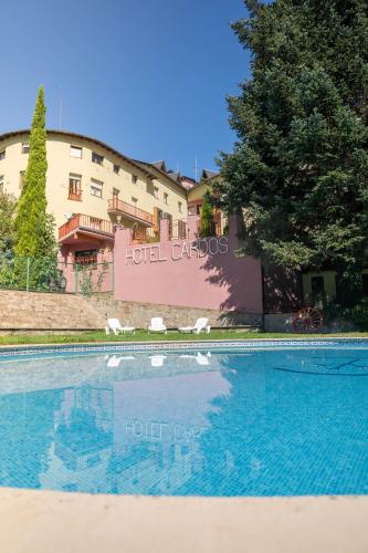 a swimming pool in front of a hotel carlos hotel city at Hotel Cardós in Ribera de Cardós