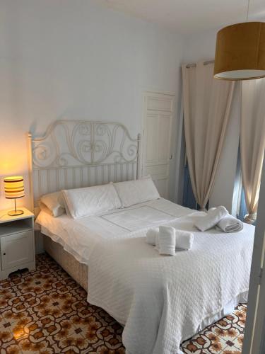 - une chambre avec un lit blanc et des serviettes dans l'établissement Casa con encanto junto Mezquita, à Cordoue