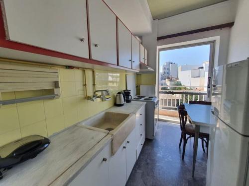 cocina con fregadero y encimera con ventana en Cozy Small Apartment City Center en Heraclión