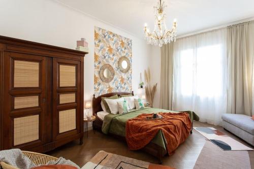 1 dormitorio con cama y lámpara de araña en L14 2P Promenade Vue Mer climatisé, spacieux/ Balcon, en Niza