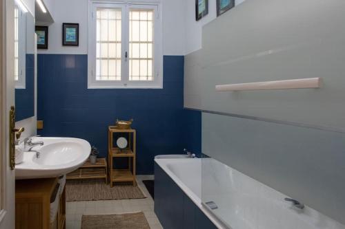 La salle de bains bleue est pourvue d'un lavabo et d'une baignoire. dans l'établissement L14 2P Promenade Vue Mer climatisé, spacieux/ Balcon, à Nice