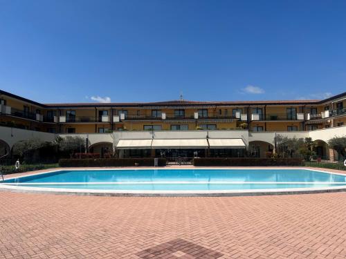a large swimming pool in front of a building at Le Terrazze sul Lago Hotel & Residence in Padenghe sul Garda