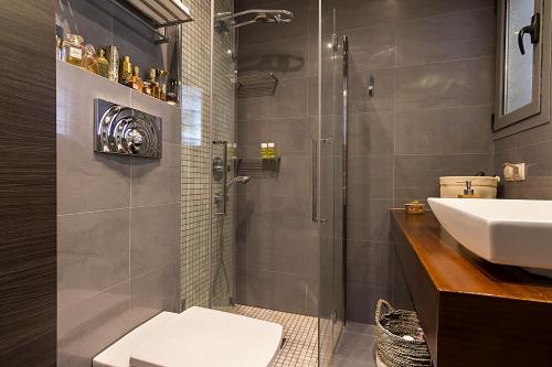 ein Bad mit einer Dusche, einem WC und einem Waschbecken in der Unterkunft Private pool & sea view residence in Saronida