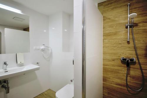 uma casa de banho com um chuveiro, um WC e um lavatório. em Hotel Hel em Hel