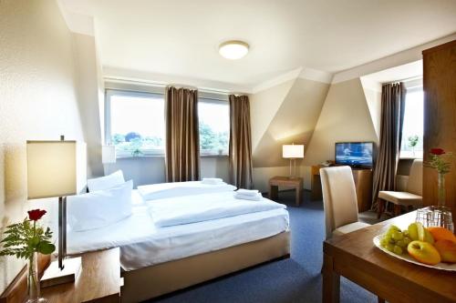 a hotel room with a bed and a table with fruit on it at Hotel Königstein Kiel by Tulip Inn in Kiel