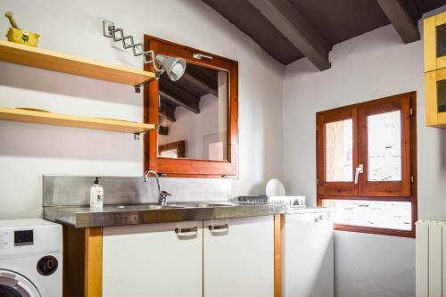 uma cozinha com um lavatório e uma máquina de lavar roupa em CAN FRUITÓS Alojamiento rural en Besalú em Besalú