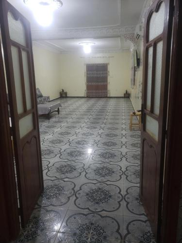 um quarto vazio com portas e piso em azulejo em Bol d'air à la mer centre Ain el Turck em Aïn el Turk