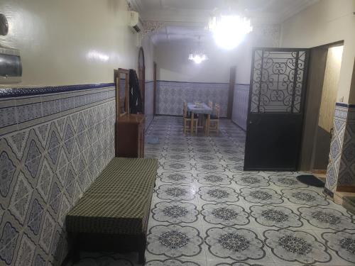 a hallway with a bench and a door and a table at Bol d'air à la mer centre Ain el Turck in 'Aïn el Turk