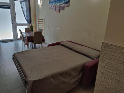 a bedroom with a bed and a table and a dining room at Appartamento via giansanti in Terracina