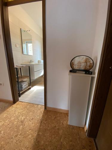 a hallway with a mirror and a sink in a bathroom at Apartma Magnolija in Nova Gorica