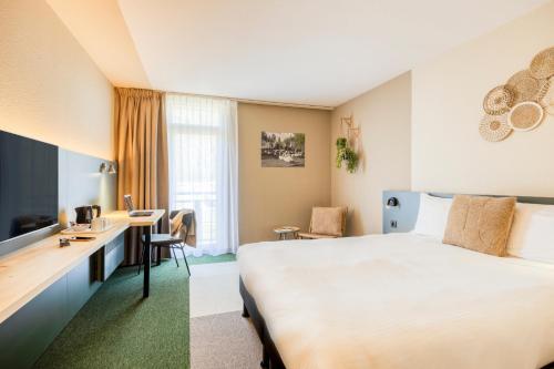 um quarto de hotel com uma cama e uma secretária em Green Park Hotel Brugge em Bruges