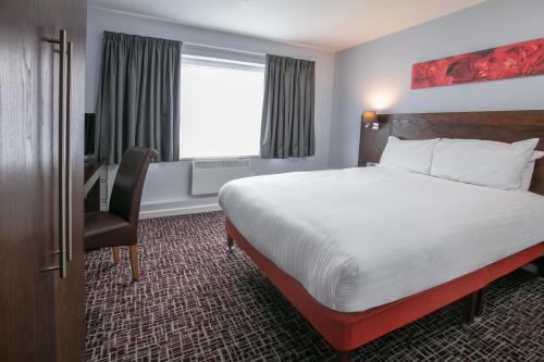 a hotel room with a bed and a desk and a window at The Stuart Hotel, Sure Hotel Collection by Best Western in Derby
