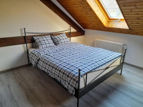 een slaapkamer met een bed in een kamer met een raam bij Studio mansardé chez un vigneron au village in Villeneuve