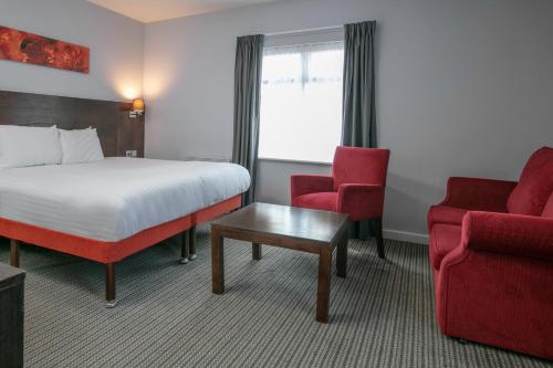 a hotel room with a bed and two chairs at The Stuart Hotel, Sure Hotel Collection by Best Western in Derby