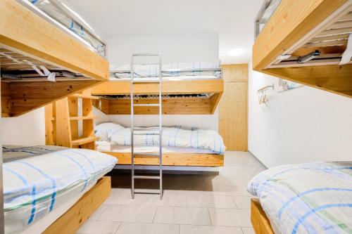 two beds in a room with bunk beds at Hotel Restaurant Berghaus Malbun Buchserberg in Buchs