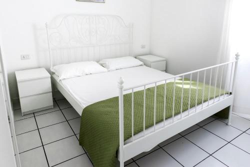 een slaapkamer met een wit bed en een groene deken bij N169 - Numana, nuova villa quadrilocale con giardino in Numana