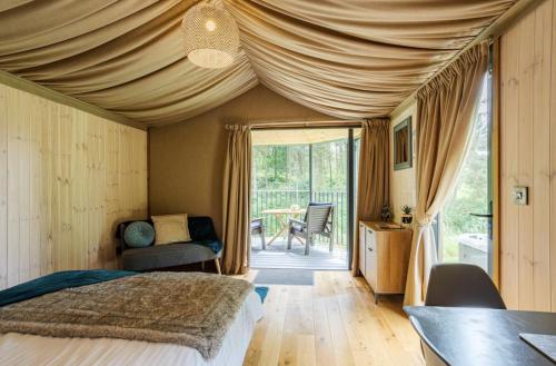 a bedroom with a bed and a table with a chair at Riverside Cabins in Shrewsbury