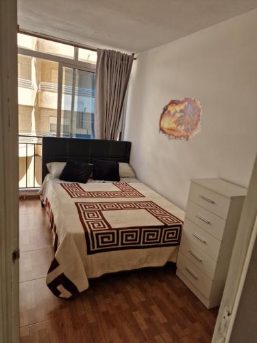 sypialnia z łóżkiem, komodą i oknem w obiekcie Aventura Playa y Sol Santa Pola w mieście Santa Pola