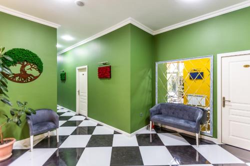 a waiting room with two blue chairs and green walls at Moss Art Boutique Hotel in Baku