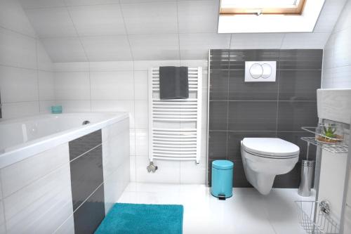 a bathroom with a tub and a toilet and a sink at Bell Nyaraló Agárd in Gárdony