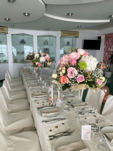a long table with white plates and flowers on it at Hotel La Lucertola in Vietri sul Mare