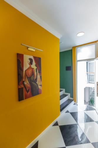 a yellow wall in a hallway with a painting on it at Moss Art Boutique Hotel in Baku