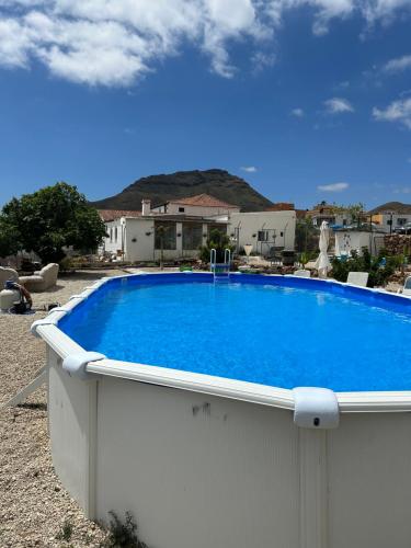 a large blue swimming pool in a yard at Casa Rural El Pasil in Arona
