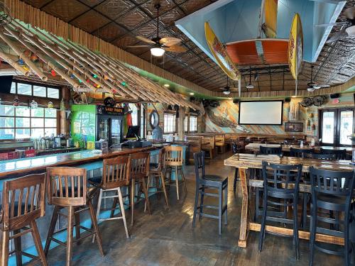 a bar with wooden chairs and tables in a restaurant at Pirates Cove in Carolina Beach