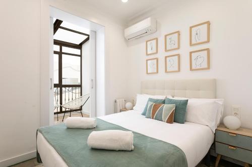- une chambre blanche avec un grand lit et une fenêtre dans l'établissement AB Passeig de Gràcia Casa Batlló, à Barcelone